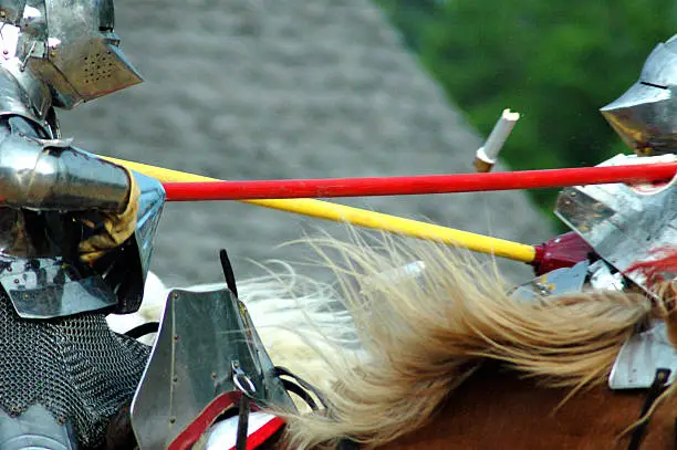 Two knights meet on the field of battle. A lance tip flies through the air.