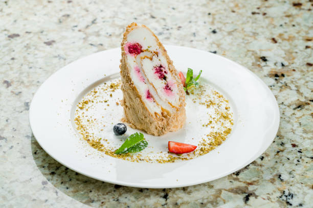 istock Meringue roll with pistachios and raspberries on a white plate on marble table 1396958008