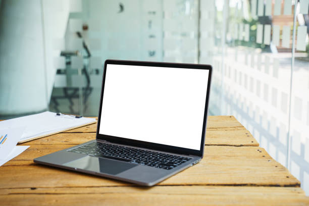 istock Laptop with blank white screen on wooden table for montage your ads. 1396960630