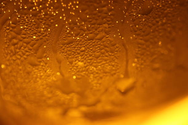 Amber back lighted frosty drink glass. Close up macro image texture. stock photo