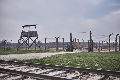 Oswiecim, Poland - March 31, 2014 : View of watchtower and electric fence with barbed wire  in the former Nazi concentration camp Auschwitz-Birkenau