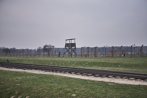 Oswiecim, Poland - March 31, 2014 : View of watchtower and electric fence with barbed wire  in the former Nazi concentration camp Auschwitz-Birkenau
