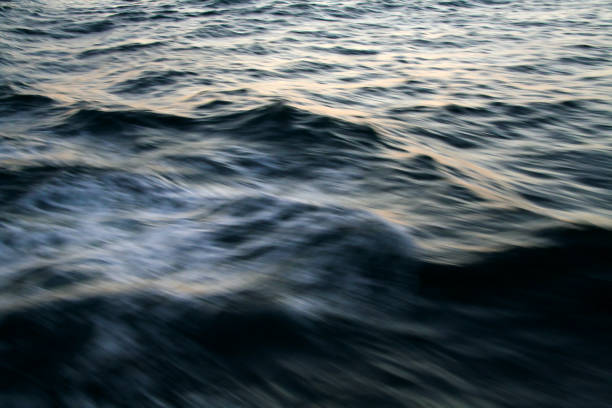 Dark ocean surface and rough wave image processed photograph, taken from the sailing boat. An image of the waves emerging in the darkness of winter from the ship during the voyage.