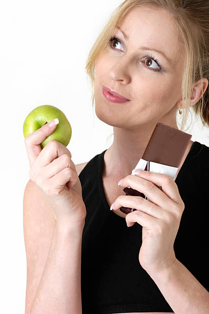 istock woman deciding whether to eat apple or chocolate 139696511