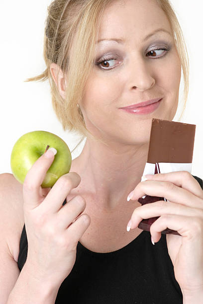 istock woman deciding whether to eat apple or chocolate 139696513