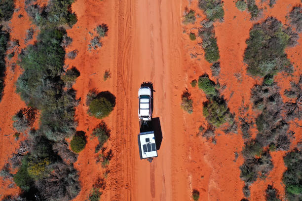 모래 비포장 도로에서 운전하는 오프로드 캐러밴을 견인하는 4wd 차량의 공중 풍경 무인 항공기보기 - outback 4x4 australia australian culture 뉴스 사진 이미지