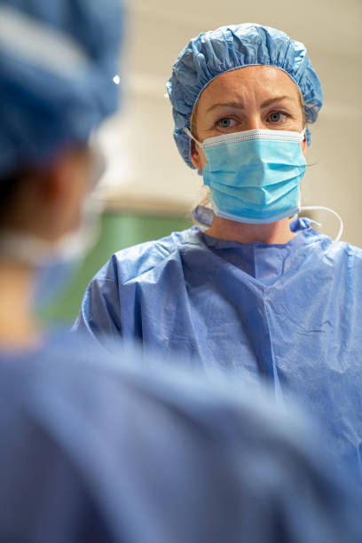 istock Female surgeon wearing protective workwear discussing with doctor during surgery 1396967766