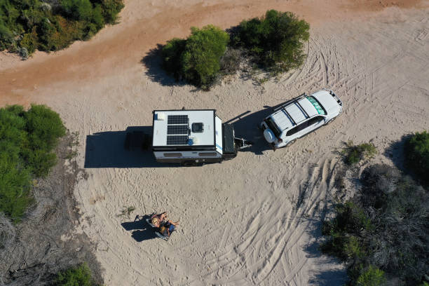 pareja australiana relajándose durante unas vacaciones en la playa con vehículo 4x4 y caravana - outback 4x4 australia australian culture fotografías e imágenes de stock