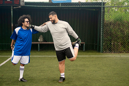 Transgender male soccer player and his friend warming up on the field