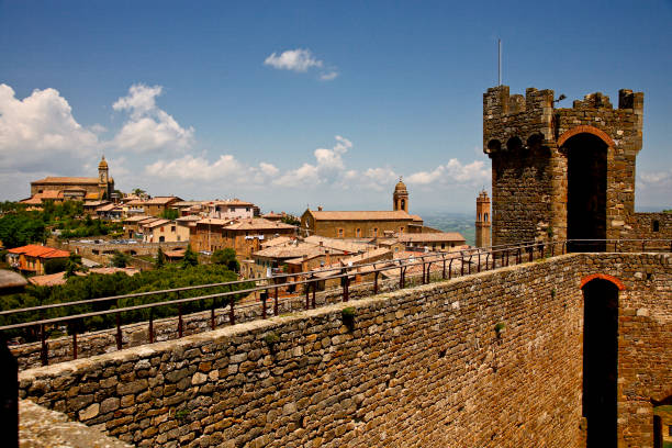 Montalcino, an ancient medieval village, place of production of a renowned red wine. Province of Siena, Tuscany, Italy A small town in the province of Siena known everywhere for the wine that is produced there, Brunello, Montalcino is a truly unmissable destination during a tour of Tuscany. We are on the western edge of the Val d'Orcia, near Mount Amiata and not far from the border with the province of Grosseto. Here, on top of a hill, lies the ancient medieval village of Montalcino, with its wonderful monuments that directly overlook the rolling Tuscan hills. - https://www.toscana.info/siena/provincia/montalcino/ crete senesi stock pictures, royalty-free photos & images