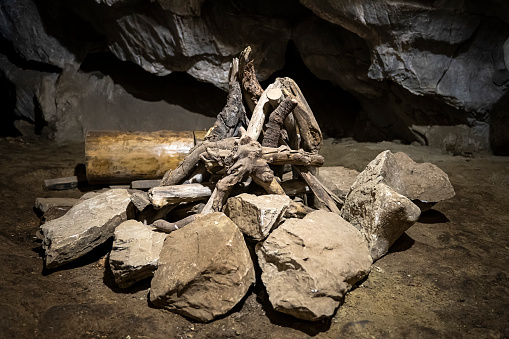 Wooden firewood in a fire in a cave. Reconstruction of the life of a caveman