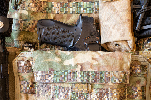 Military reinforced bulletproof vest and pistol, weapon, uniform