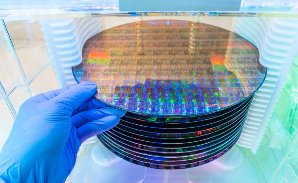 istock Gloved Hand Holding a Silicon Wafer in plastic holder box used in electronics for the fabrication of integrated circuits 1396973491