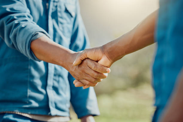 cropped shot of two unrecognisable farmers standing together and shaking hands - trabalho agrícola imagens e fotografias de stock