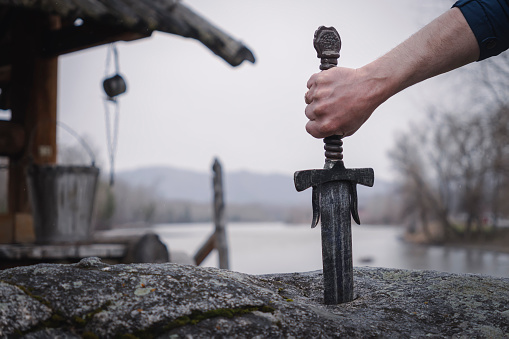 famous sword excalibur of King Arthur stuck in the rock. Edged weapons from the legend Pro king Arthur.