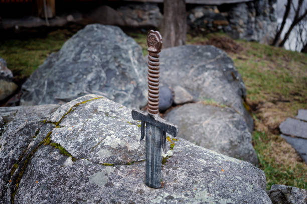 famous sword excalibur of King Arthur stuck in rock. Edged weapons from the legend Pro king Arthur. famous sword excalibur of King Arthur stuck in the rock. Edged weapons from the legend Pro king Arthur. sword photos stock pictures, royalty-free photos & images