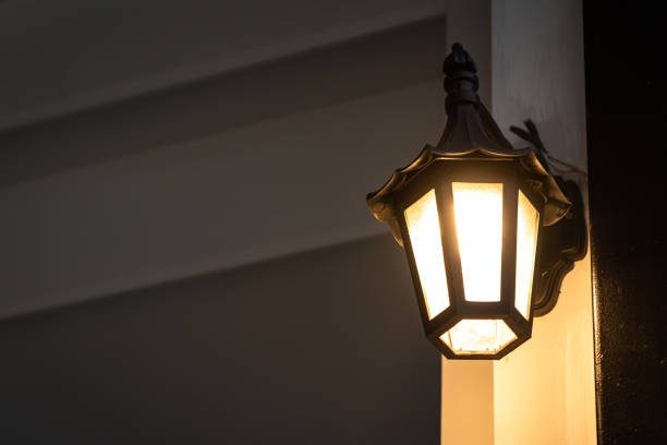 istock A classic style street lighting lamp is glowing in orange warm light. 1396975755