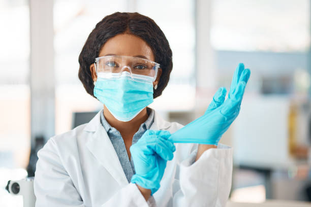 istock Portrait of a young scientist putting on gloves while working in a lab 1396976101