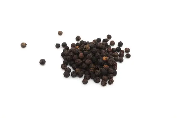 Photo of Whole black pepper spice or Piper nigrum dried berries isolated on white background.