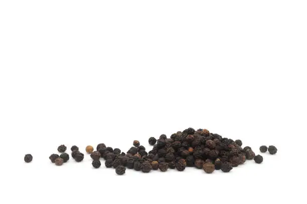 Photo of Whole black pepper spice or Piper nigrum dried berries isolated on white background.