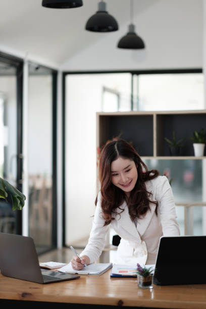 istock Business asian woman using laptop computer for financial analysis at her office 1396978823