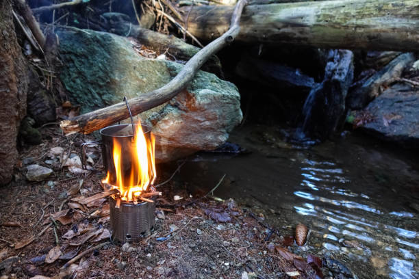 istock bushcrafting with a pot and boiling water over a fire 1396978921