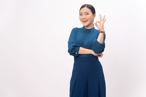 Asian woman happy showing OK sign standing isolated on white background.