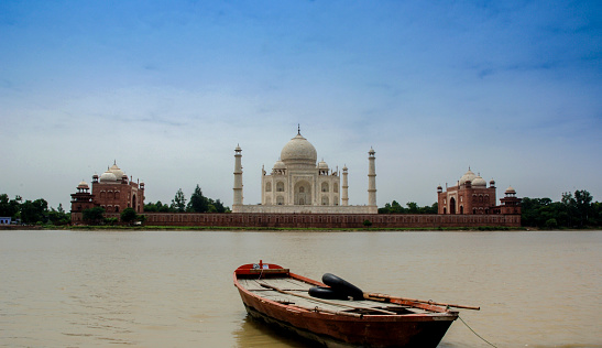 A fresh and clean view of the Taj Mahal at Yamuna river with boat.