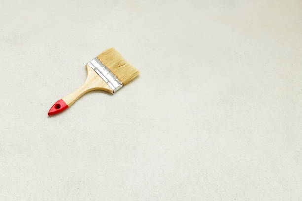 Paint brush on concrete floor, copy space