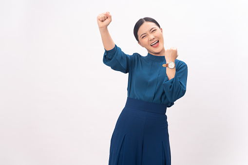 Asian woman happy confident showing her fist make a winning gesture standing isolated on white background.