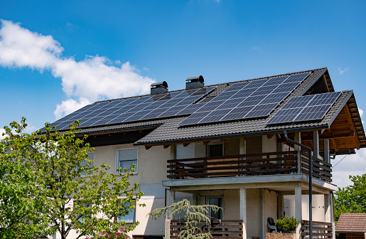 Solar panels producing clean energy on a roof of a residential house, sustainable energy concept