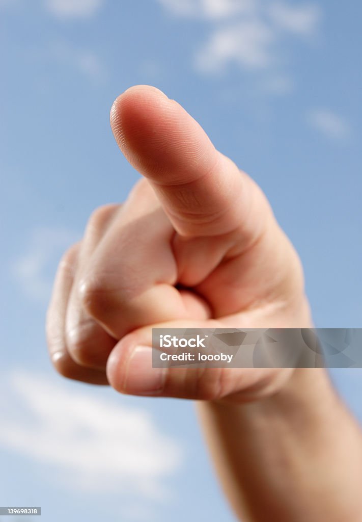pointing finger finger pointing,blue sky as background,finger-tip sharp Accessibility Stock Photo
