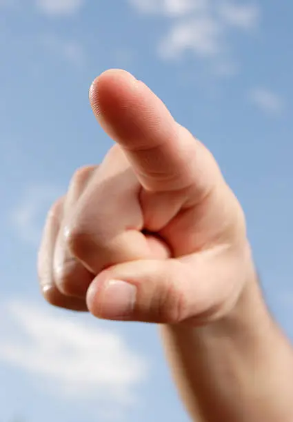 finger pointing,blue sky as background,finger-tip sharp