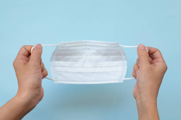 istock Hold the mask with both hands, put on the mask, remove the mask 1396984627
