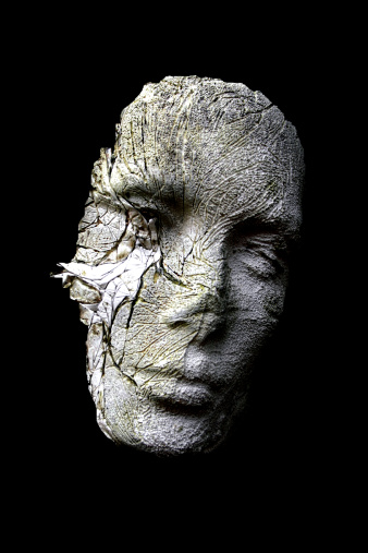 Abstract home made plaster head having been weathered, cut out against a black background. For possible use in metaphorical or conceptual scenario,