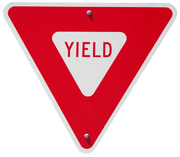 Red yield traffic sign against a white background stock photo