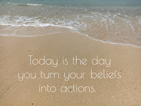 Inspirational motivational quote - Today is the day you turn your beliefs into actions. Positive words on the sand with aerial view of white sand and wave pattern on the beach.