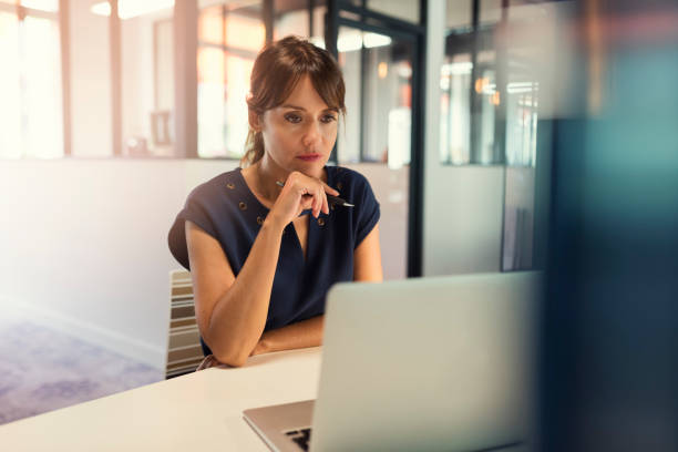istock Concentrated middle aged woman working on her computer. Start-up  office background 1396993756