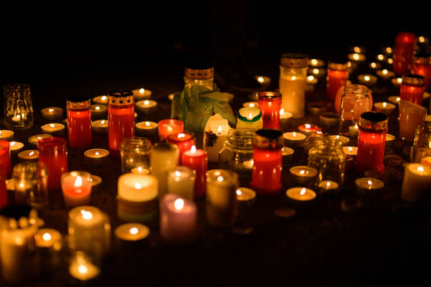 Many candles burning on the ground in the night, protest against war