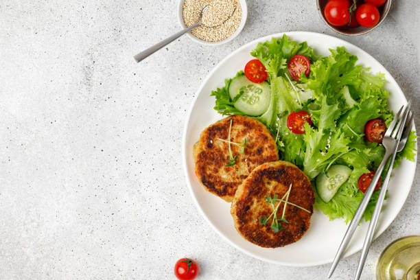 roasted homemade quinoa cutlets with vegetable salad on white plate. top view, flat lay, copy space. vegan food - cutlet imagens e fotografias de stock