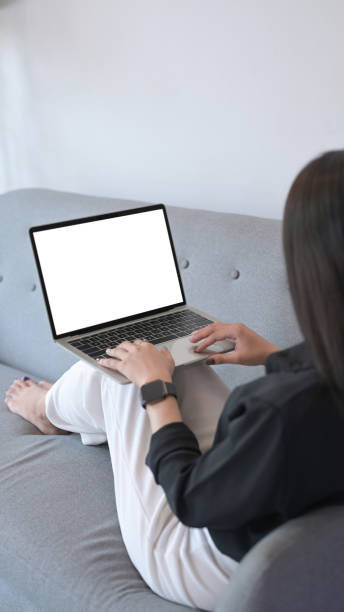 istock Casual woman resting on sofa and surfing internet with laptop computer. 1396997173