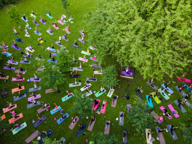 overhead view of people do yoga at city public park stock photo