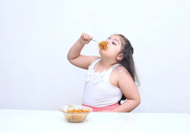 ファーストフードを食べるインドの小さな女の子 - overweight child eating hamburger ストックフォトと画像