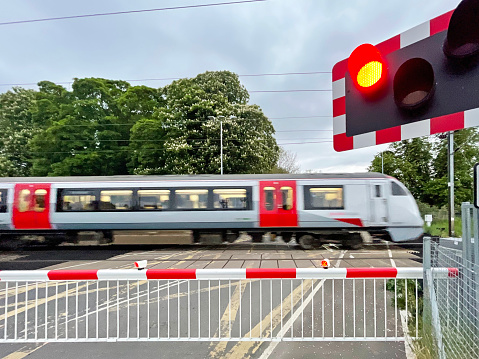 Railway crossing as train passes at speed