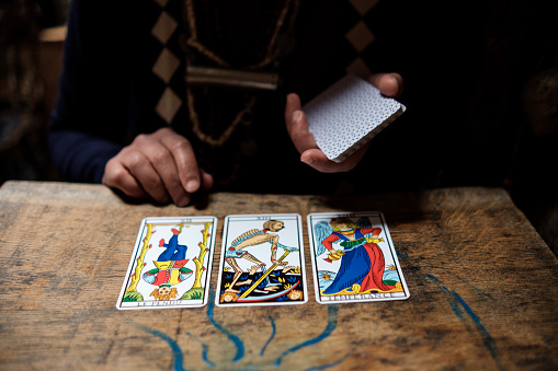 Close up of psychic reader cards on a wood table.