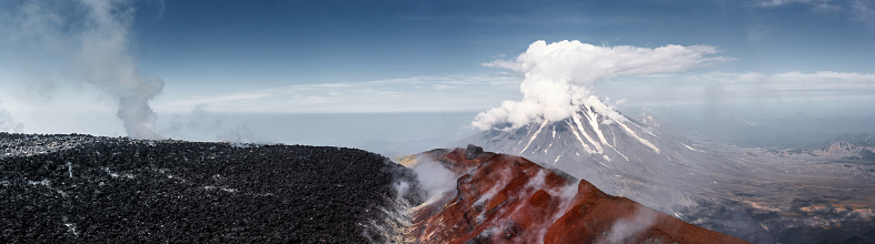 Panorama of Koryaksky volcano, view from Avachinsky volcano top, black stones of solidified lava, Kamchatka