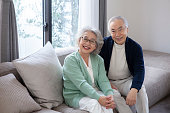 Portrait of asian senior couple relaxing in a modern living room.