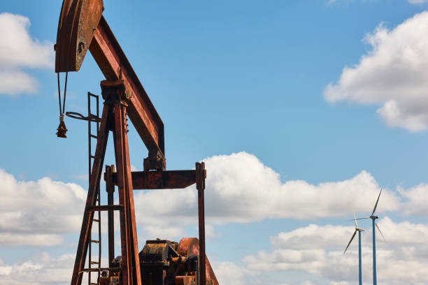 istock Oil pumping machine and windmills. Petroleum extraction. Global warming 1397007277