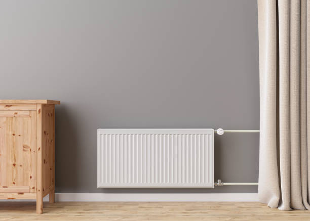 istock White heating radiator with thermostat on grey wall in modern room. Central heating system. Free, copy space for your text. 3D rendering. 1397007309