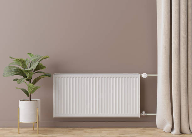 istock White heating radiator with thermostat on brown wall. Central heating system. Free, copy space for your text. 3D rendering. 1397007315